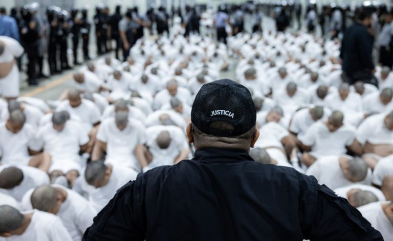 TECOLUCA, EL SALVADOR - MARCH 16: In this handout photo provided by the Salvadoran government,  a guard watches the inmates allegedly linked to criminal organizations sitting on the floor at CECOT on March 16, 2025 in Tecoluca, El Salvador. Trump's administration deported 238 alleged members of the Venezuelan criminal organizations 'Tren De Aragua' and Mara Salvatrucha with only 23 being members of the Mara. Nayib Bukele president of El Salvador announced that his government will receive the alleged members of the gang to be taken to CECOT. On February of 2023 El Salvador inaugurated Latin America's largest prison as part of President Nayib Bukele's plan to fight gangs. (Photo by Salvadoran Government via Getty Images)